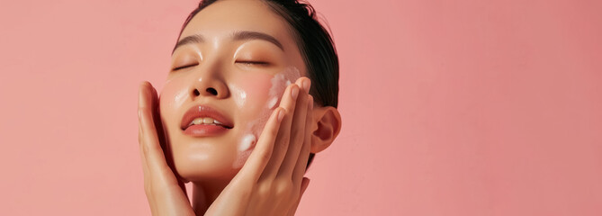 refreshing skincare regime with woman enjoying facial product on rosy background with large  copy space   - obrazy, fototapety, plakaty