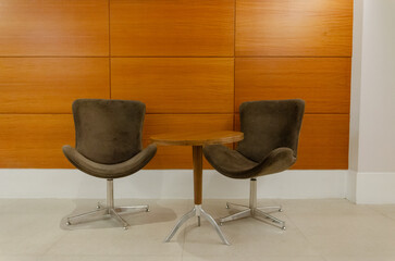 two chairs and a table in a room with wooden walls