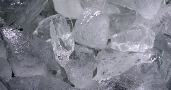 Pieces of ice in the container. Chilled water. Shine from natural crystals.