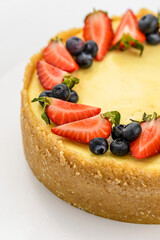 cheesecake cake with berries on a white background