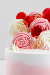 cake with meringue and lollipops on a white background