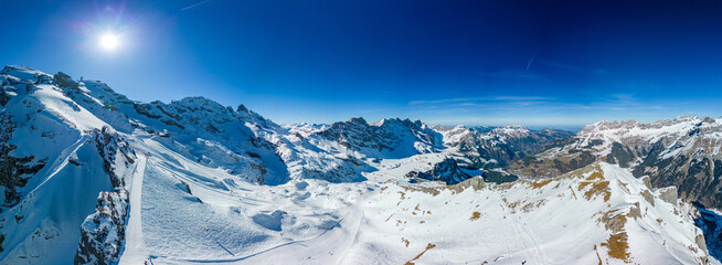 Fototapeta na wymiar Aerial panoramic winter landscape in Swiss Alps, famous Engelgerg - Titlis ski resort, Switzerland