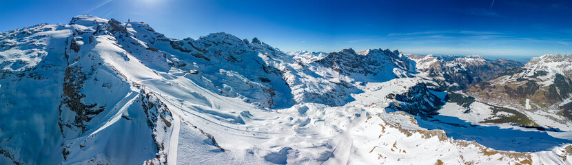 Fototapeta na wymiar Aerial panoramic winter landscape in Swiss Alps, famous Engelgerg - Titlis ski resort, Switzerland