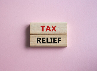 Tax Relief symbol. Concept word Tax Relief on wooden blocks. Beautiful pink background. Business and Tax Relief concept. Copy space