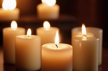 Fototapeta na wymiar Several lighten candles on wooden surface on dark background