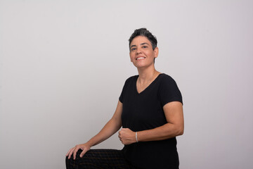 Obraz premium Beautiful short-haired woman wearing black clothes looking and smiling at the camera.