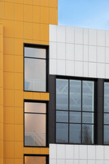 Fragment of new commercial complex. Yellow-brown modern ventilated facade with large windows. Part of urban property