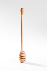 Honey dipper, drizzler, wooden kitchen utensil for collecting honey, isolated on white