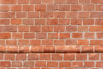 Wall texture with red bricks, geometric background with horizontal row of protruding, round red bricks, Background with copy space