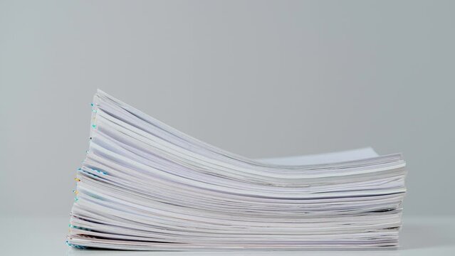 Time lapse studio shot of paper sheets. Stop motion animation of business or educational paper documents with paper clips at the desk