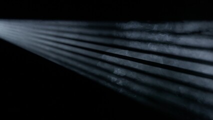 Studio shot of projector haze jalousie effect isolated on black background. Monochrome light rays...