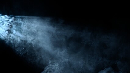 Studio shot of projector haze effect isolated on black background. Cold white colored rays shining...