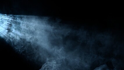 Studio shot of projector haze effect isolated on black background. Cold white colored rays shining from side with smoke.