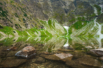 Polish Tatra Mountains, Czarny Staw, view from the trail and the shore of a pond with clear water at the foot of the mountain
