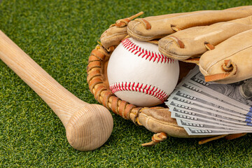 Baseball, glove and wooden bat with cash money. Baseball salary expenses and sports gambling...