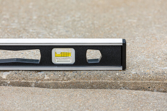 Concrete driveway cracked and settling. Home inspection, slab jacking and sidewalk repair concept.