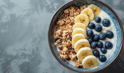 Granola bowl. Yogurt and muesli with fresh banana slices, blueberry and peanut butter in ceramic bowl. Top view - Powered by Adobe