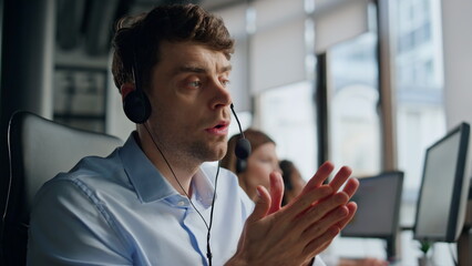 Closeup technical assistant talking in call center. Focused man listening client