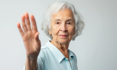 Elderly woman gesturing "stop" to symbolize her stand against ageism and advocate for women's rights, on light background, with copy space 