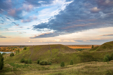 Naklejka premium View of a hill in the countryside, evening landscape with sunset sky
