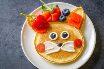 Funny food for kids. Bear and cat made of pancakes with strawberries. Idea for a baby breakfast. Top view, flat lay. Creative breakfast ideas for kids