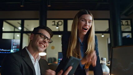 Joyful colleagues celebrate success in office. Happy traders team look computer