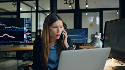 Stressed broker talking mobile phone in office. Upset woman get bad news on call