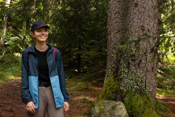 Autumn hike tourist lifestyle woman walking on trek trail in forest outdoors. Summer, autumn active girl with a backpack hiking outdoors.