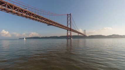 Red bridge 25 de Abril Bridge and statue of Cristo Rei during a slightly misty day, Lisbon, Portugal