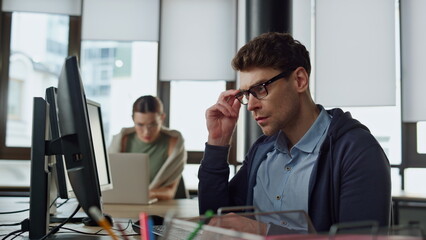 Thoughtful office manager typing computer. Focused software engineer programming