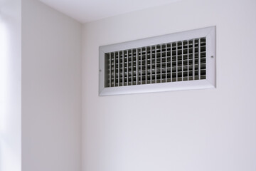 metal air conditioner radiator on the white wall, climate control and ventilation equipment 
