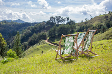 Wooden chairs, with plant fabrics, in the green mountains.