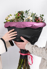 A guy gives a girl a bouquet of flowers.