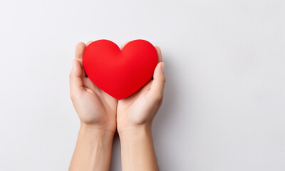Male hand holding red paper heart on light background with space for text.