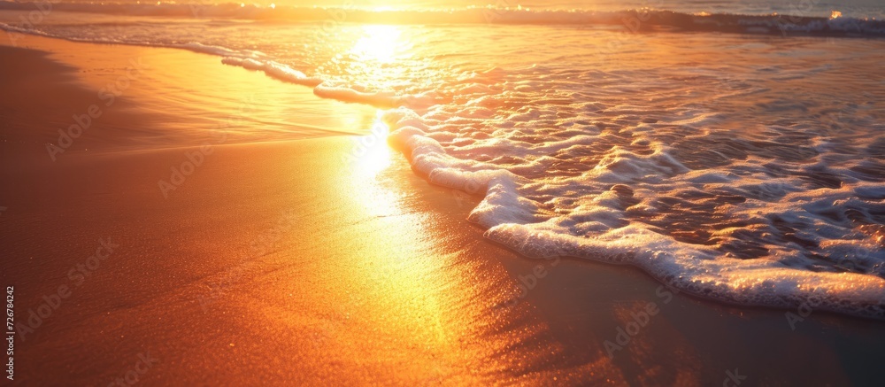 Sticker sunset on the beach, the sun's rays reflected in the waves of the sea.