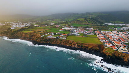 Aerial luxury resort village at seaside cliff. Woodland hills valley buildings
