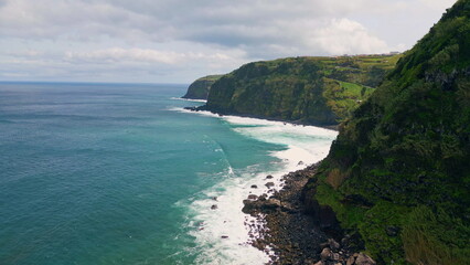 Foaming waves breaking hills drone view. Gloomy coastal landscape ocean surfs