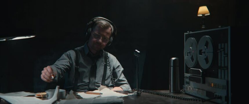 An intelligence officer listens to the recording and pours his coffee