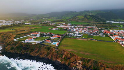 Gloomy coastal resort landscape drone view. Residential complex on woodland hill