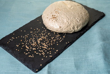 Sesame halva on stone black board with blue background.