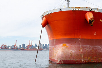 The bow of a container ship which is anchored in Vancouver Harbour with the Vancouver, British...
