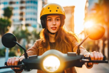 Poster Young woman driving electric scooter in city, wearing yellow helmet. Sunset © VisualProduction