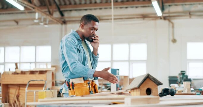 Black man, carpenter and phone call in stress, anxiety or argument for discussion, problem or issue at workshop. Frustrated African male, builder or craftsman talking on mobile smartphone in pressure