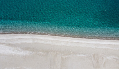 Aerial view of a clean beach with crystal blue water