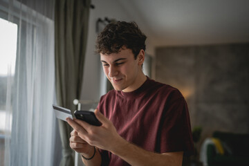 teenager young man sit at home use credit card shopping online