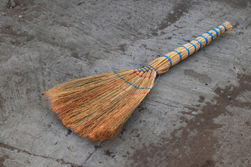 A new broom or cleaning agent lying on a dirty concrete base