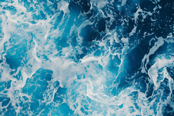 Fototapeta premium Abstract view of swirling blue and white foam patterns resembling ocean waves.