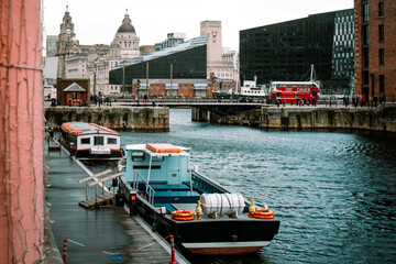 Fototapeta na wymiar Liverpool, UK - October 10 2023 : Albert Dock, no logos or recognizable people with boats docked in the harbour and famous maritime landmarks in the background with old and modern architecture