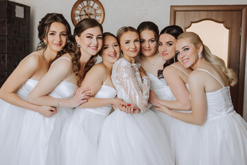 A beautiful bride and her bridesmaids are having fun in the morning. Wedding celebration. Happy...