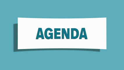 Agenda. Eine weisse Karte mit blaugruener Schrift und Schatten, isoliert auf blaugruenem Hintergrund.
